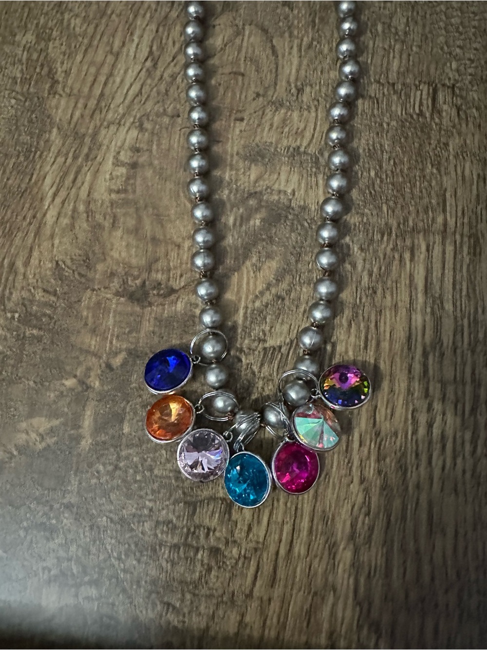 New silver beaded necklace has 7 multi colored circle charms.